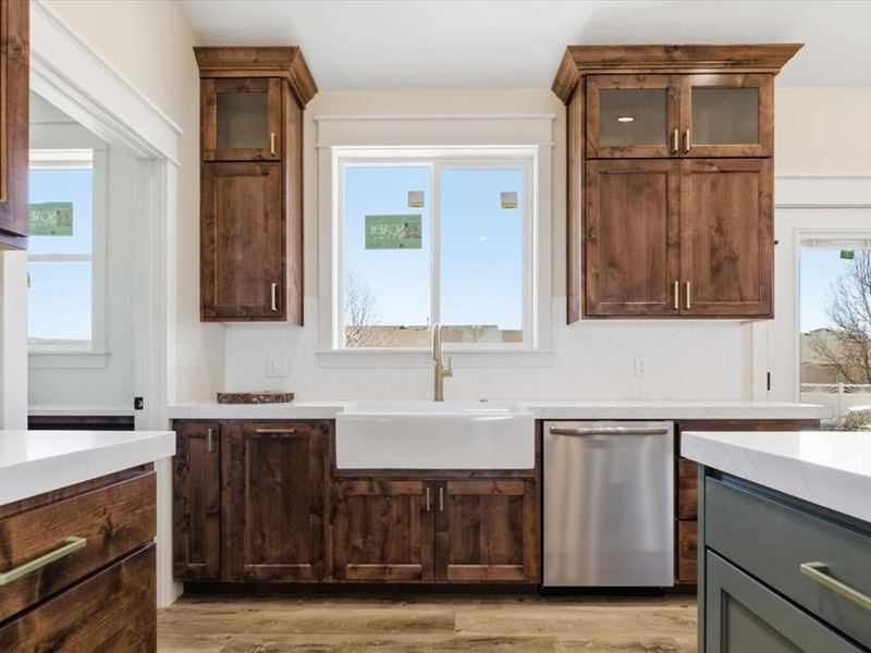 Farmhouse-style sink wall with stained cabinets and stainless appliances