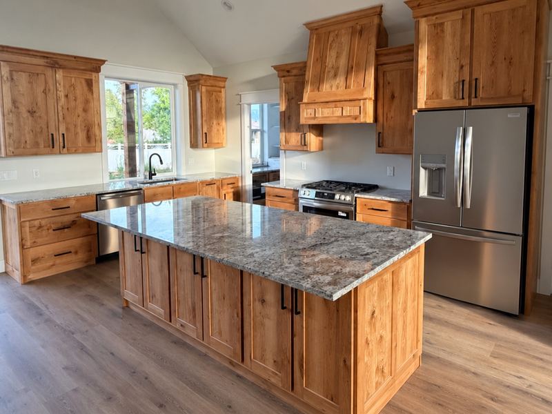 Kitchen with stained wood cabinets, a granite-topped island, and stainless appliances