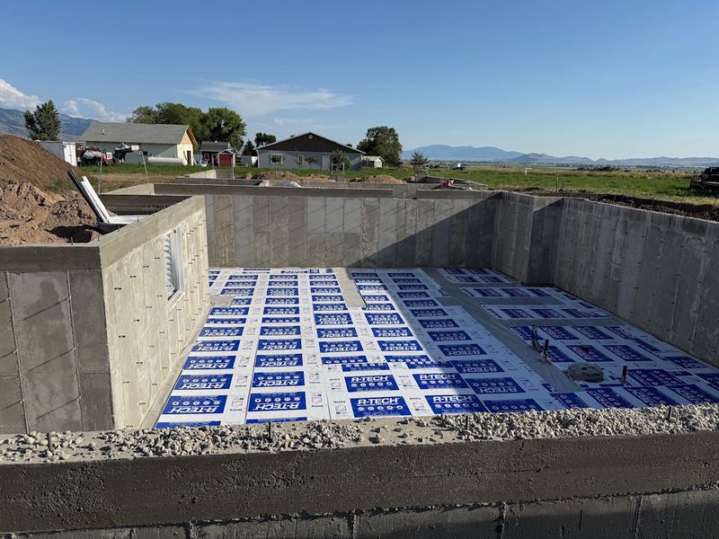 Rigid foam insulation laid across the basement before the slab