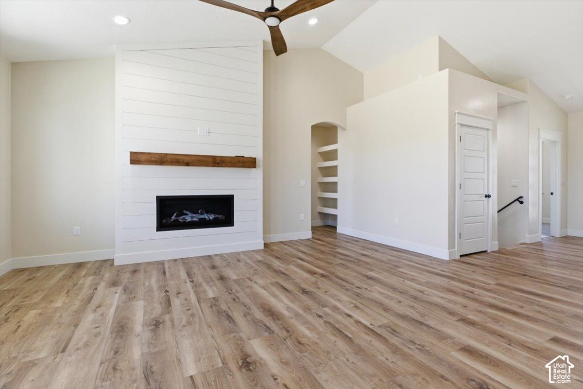 Great room at 816 S 1100 E with a linear fireplace, wood floors, and a ceiling fan