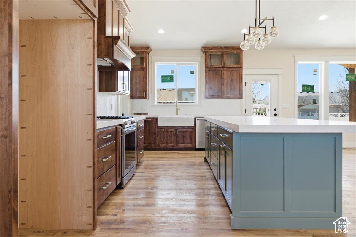 Kitchen at 816 S 1100 E, Preston, Idaho, with wood cabinets, a blue-gray island, and pendant lights
