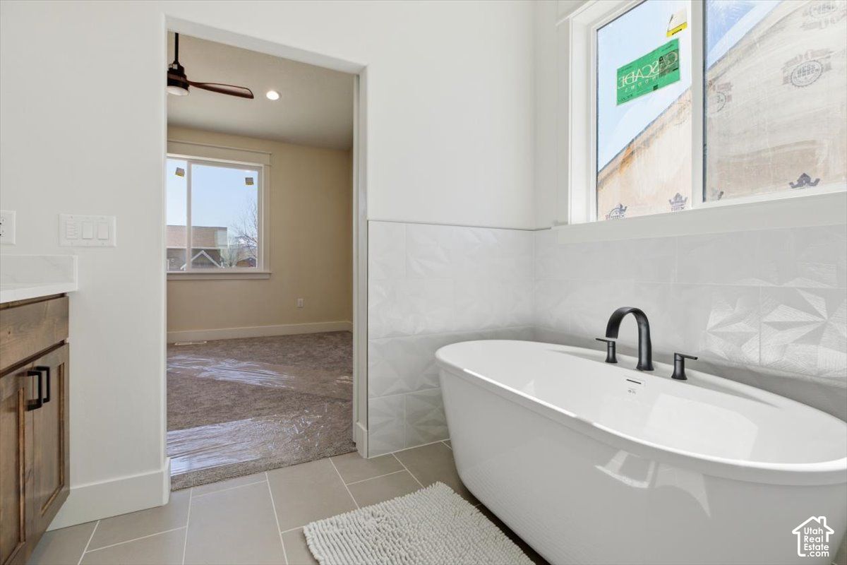 Primary bathroom at 816 S 1100 E with a freestanding tub, tile floor, and wood vanity