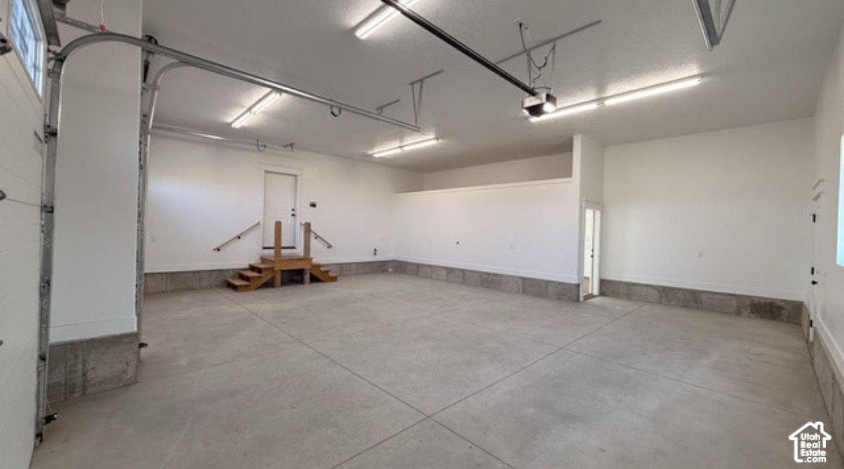 Large empty garage at 832 S 1100 E with a concrete floor and overhead door openers