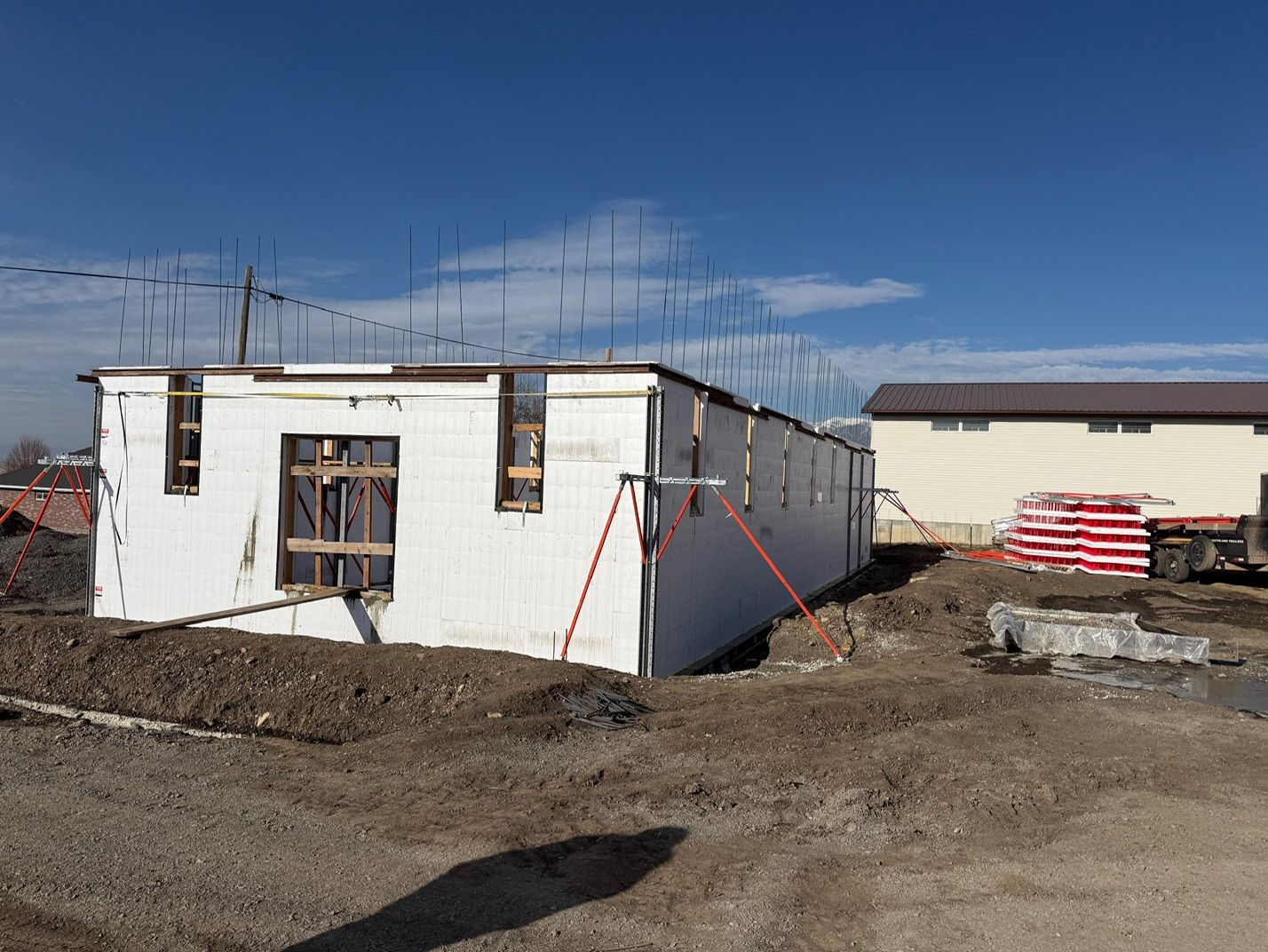 White ICF walls forming the shell of a building, with window bucks and bracing in place